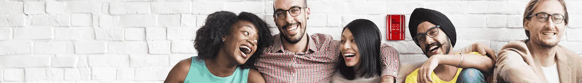 People smiling in front of a brick wall